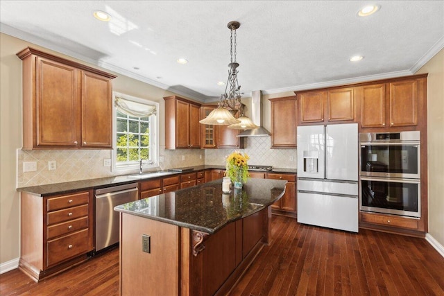 3144 Abbey Knoll Dr, Lewis Center, OH 43035 - kitchen featuring stainless steel appliances, wall chimney range hood, brown cabinets, dark wood finished floors, and crown molding