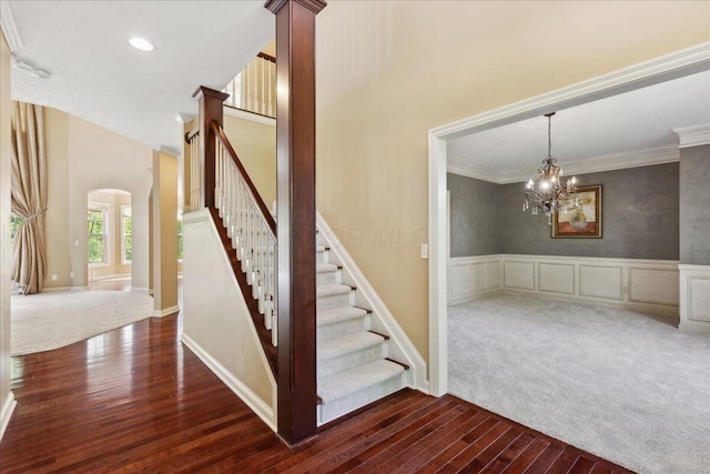 3144 Abbey Knoll Dr, Lewis Center, OH 43035 - stairway with hardwood / wood-style flooring, crown molding, arched walkways, a chandelier, and a wainscoted wall