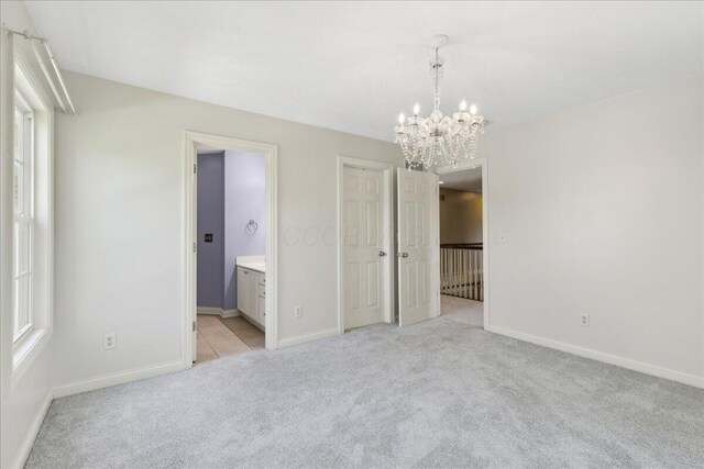 3144 Abbey Knoll Dr, Lewis Center, OH 43035 - unfurnished bedroom with a chandelier, light carpet, baseboards, and connected bathroom