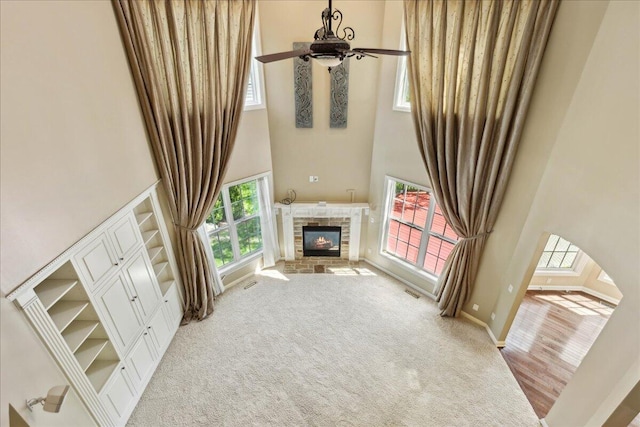 3144 Abbey Knoll Dr, Lewis Center, OH 43035 - unfurnished living room with a towering ceiling, a ceiling fan, a fireplace, light colored carpet, and baseboards