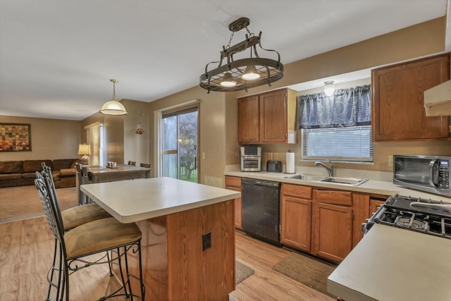 6792 Makady Rd, Canal Winchester, OH 43110 - kitchen featuring black dishwasher, a sink, light wood-type flooring, a kitchen island, and light countertops