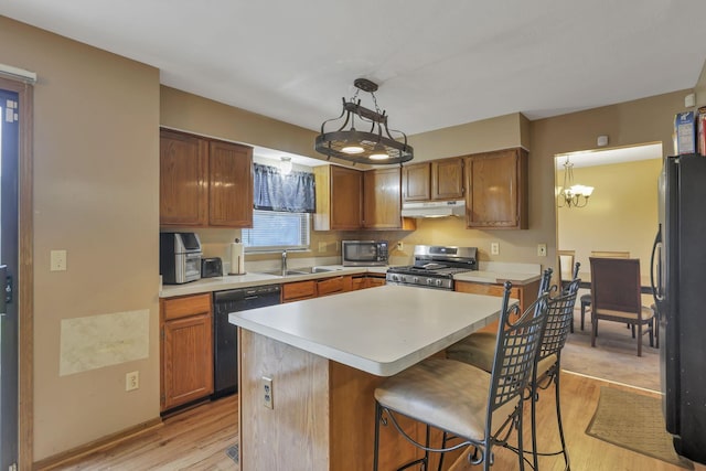 6792 Makady Rd, Canal Winchester, OH 43110 - kitchen featuring black appliances, under cabinet range hood, light wood-style floors, and light countertops