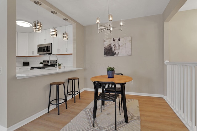 1722 Rock Creek Dr, Grove City, OH 43123 - dining space with a chandelier, light wood-style flooring, and baseboards