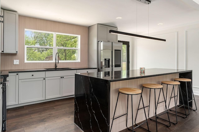 1071 US-42, London, OH 43140 - kitchen featuring stainless steel refrigerator with ice dispenser, a sink, a breakfast bar, and dark wood-style flooring