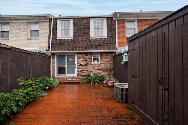 2349 Hardesty Dr N Unit B9, Columbus, OH 43204 - rear view of property with mansard roof, brick siding, a shingled roof, a patio area, and central AC