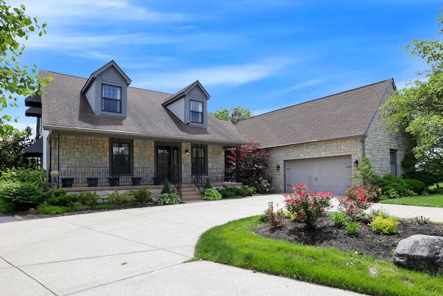 3171 Orders Rd, Grove City, OH 43123 - cape cod-style house with stone siding, covered porch, concrete driveway, and a garage