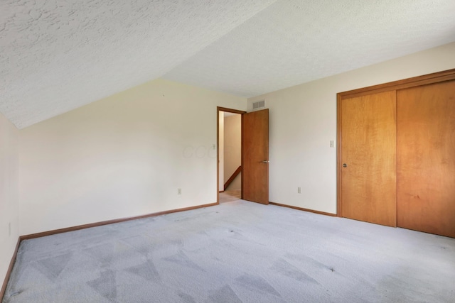 3171 Orders Rd, Grove City, OH 43123 - unfurnished bedroom with a textured ceiling, light colored carpet, baseboards, a closet, and lofted ceiling
