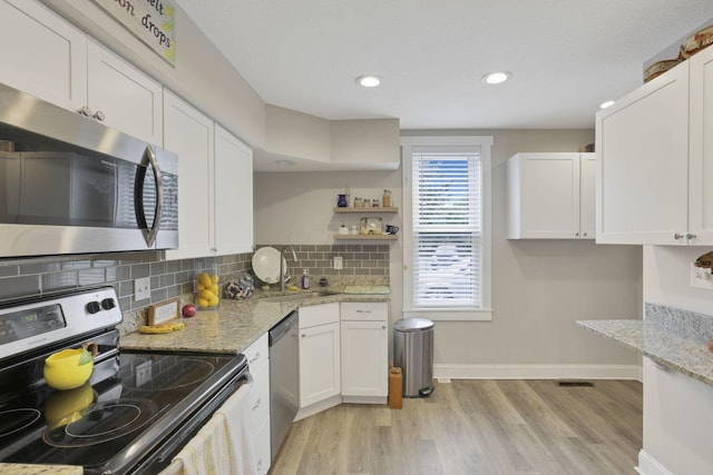 402 W St, Groveport, OH 43125 - kitchen featuring appliances with stainless steel finishes, white cabinetry, a sink, light wood-type flooring, and recessed lighting