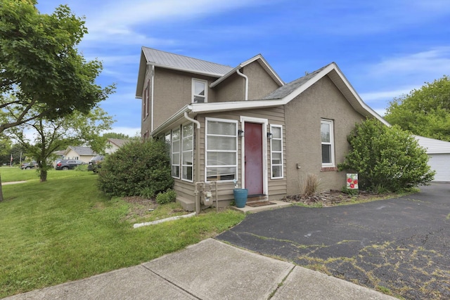 402 W St, Groveport, OH 43125 - view of front facade with a front lawn, a garage, stucco siding, and metal roof
