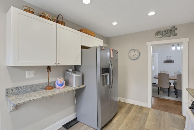 402 W St, Groveport, OH 43125 - kitchen with stainless steel fridge with ice dispenser, white cabinetry, baseboards, light wood-style flooring, and light stone countertops