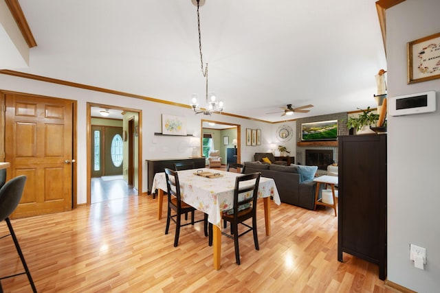 1055 Arcaro Dr, Columbus, OH 43230 - dining space with a ceiling fan, light wood-style flooring, a brick fireplace, a chandelier, and ornamental molding