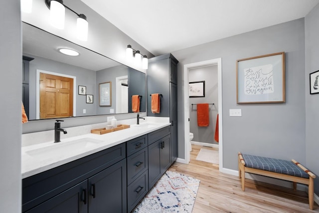 1055 Arcaro Dr, Columbus, OH 43230 - bathroom with double vanity, toilet, wood finished floors, and baseboards