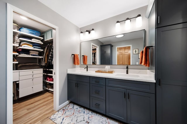 1055 Arcaro Dr, Columbus, OH 43230 - full bathroom featuring double vanity, a spacious closet, wood finished floors, and baseboards