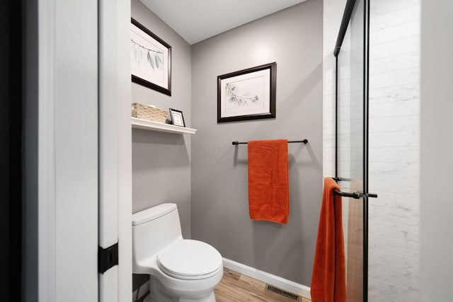 1055 Arcaro Dr, Columbus, OH 43230 - bathroom featuring toilet, wood finished floors, baseboards, and tiled shower