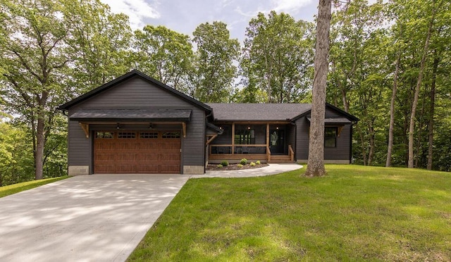 21650 Lake Rd, Glouster, OH 45732 - view of front of home featuring a garage, concrete driveway, a front yard, and covered porch
