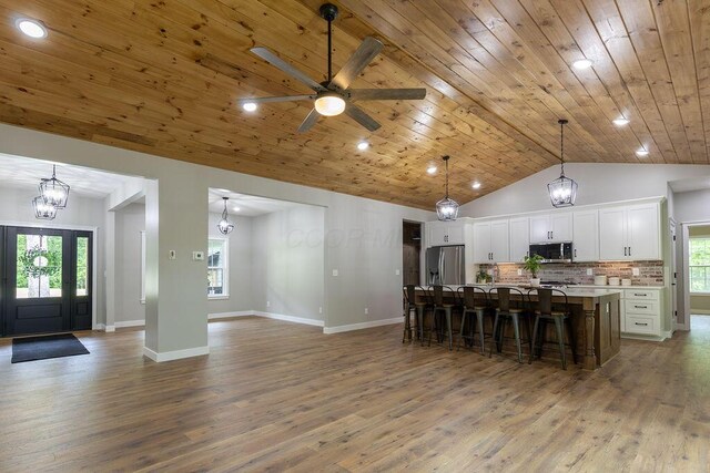 21650 Lake Rd, Glouster, OH 45732 - kitchen with appliances with stainless steel finishes, wood finished floors, a kitchen bar, white cabinets, and wooden ceiling