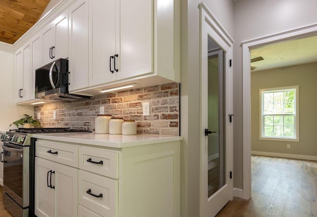 21650 Lake Rd, Glouster, OH 45732 - kitchen featuring appliances with stainless steel finishes, backsplash, light wood finished floors, light countertops, and white cabinets