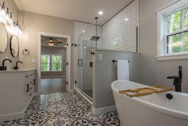 21650 Lake Rd, Glouster, OH 45732 - full bath with vanity, a stall shower, a freestanding bath, a ceiling fan, and baseboards