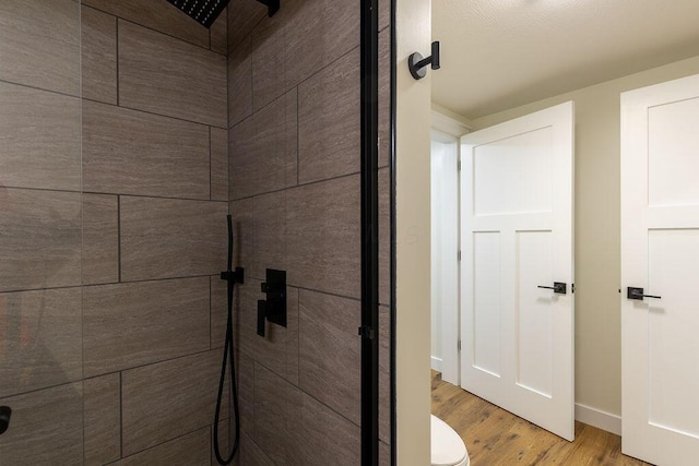 21650 Lake Rd, Glouster, OH 45732 - full bathroom featuring tiled shower, wood finished floors, toilet, and baseboards
