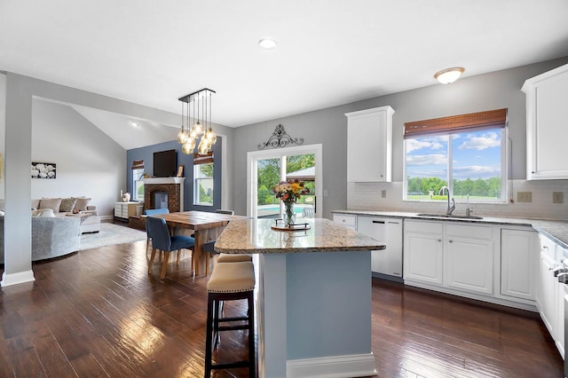 401 Warrenpoint Ln, Pataskala, OH 43062 - kitchen with stainless steel dishwasher, a sink, open floor plan, lofted ceiling, and decorative backsplash