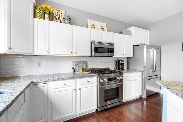 401 Warrenpoint Ln, Pataskala, OH 43062 - kitchen with appliances with stainless steel finishes, backsplash, dark wood-type flooring, and white cabinets