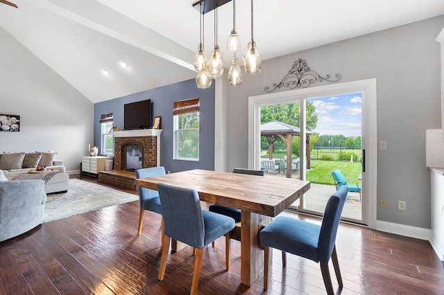 401 Warrenpoint Ln, Pataskala, OH 43062 - dining space with a brick fireplace, hardwood / wood-style floors, baseboards, vaulted ceiling, and a chandelier