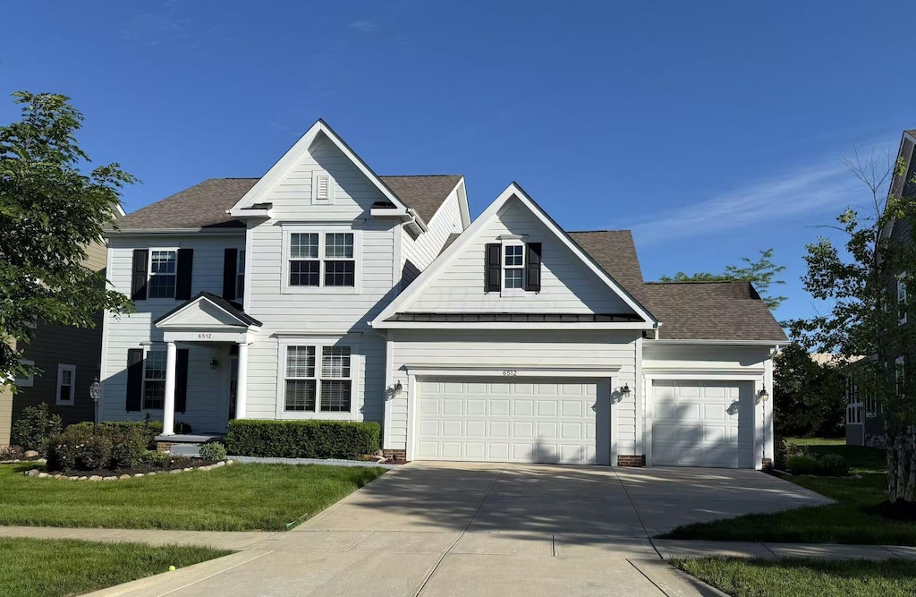 6512 Dicesare Loop, Dublin, OH 43016 - traditional-style home with driveway, a front lawn, an attached garage, and roof with shingles