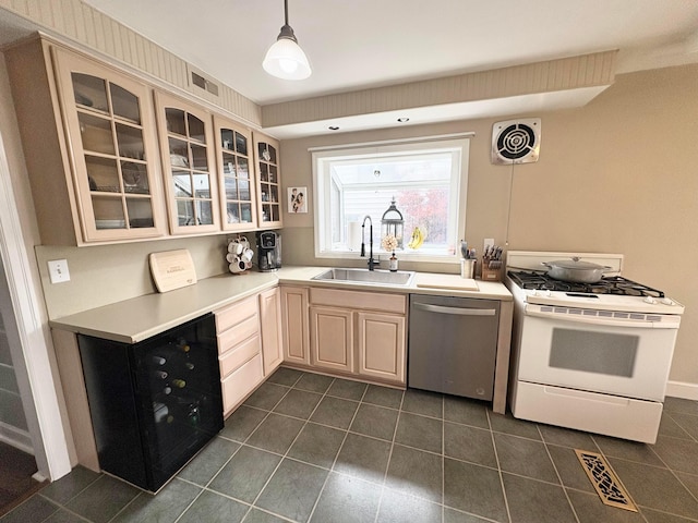 2010 S Main St, Findlay, OH 45840 - kitchen featuring stainless steel dishwasher, white gas range oven, a sink, and dark tile patterned floors