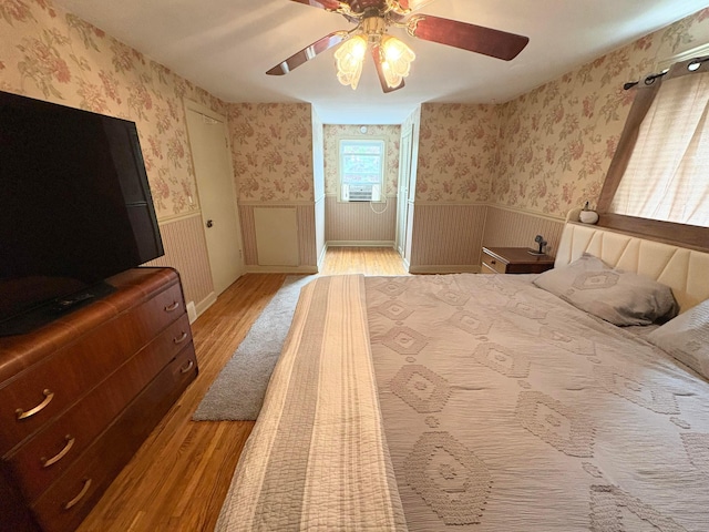 2010 S Main St, Findlay, OH 45840 - bedroom with wallpapered walls, light wood-style flooring, wainscoting, cooling unit, and ceiling fan