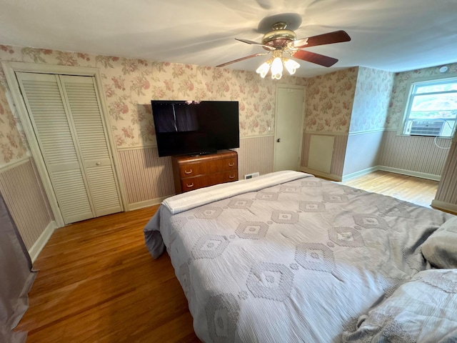 2010 S Main St, Findlay, OH 45840 - bedroom with wood finished floors, wainscoting, wallpapered walls, and ceiling fan