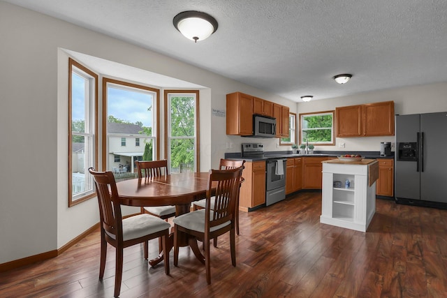 2016 Sondra Ln, Grove City, OH 43123 - kitchen featuring appliances with stainless steel finishes, dark wood-type flooring, a textured ceiling, a sink, and a kitchen island