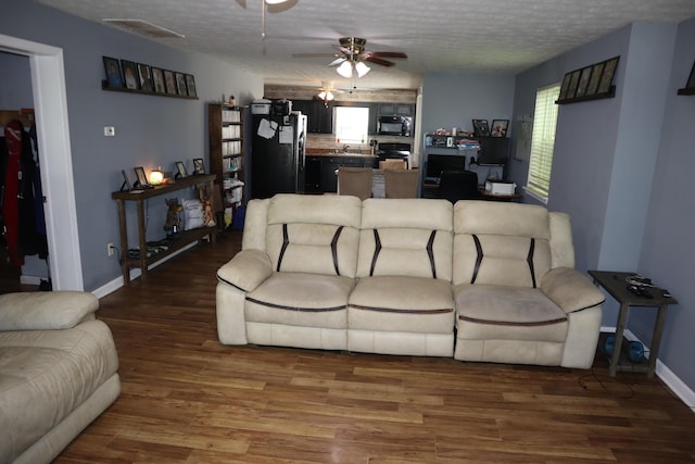 1131 Campbell St, Washington Court House, OH 43160 - living area featuring wood finished floors, plenty of natural light, a ceiling fan, a textured ceiling, and baseboards