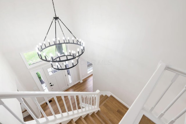 6377 Dietz Dr, Canal Winchester, OH 43110 - stairs featuring a chandelier, wood finished floors, a high ceiling, and baseboards