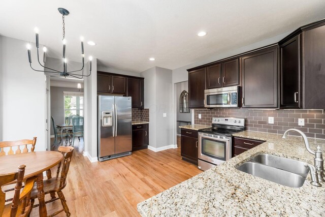 6458 Tallman Ct, Canal Winchester, OH 43110 - kitchen featuring appliances with stainless steel finishes, a sink, dark brown cabinetry, backsplash, and recessed lighting