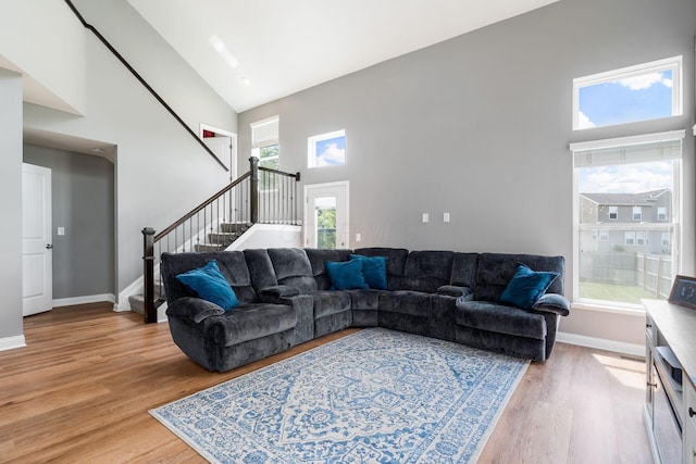 6458 Tallman Ct, Canal Winchester, OH 43110 - living area with high vaulted ceiling, stairway, light wood-style floors, and baseboards