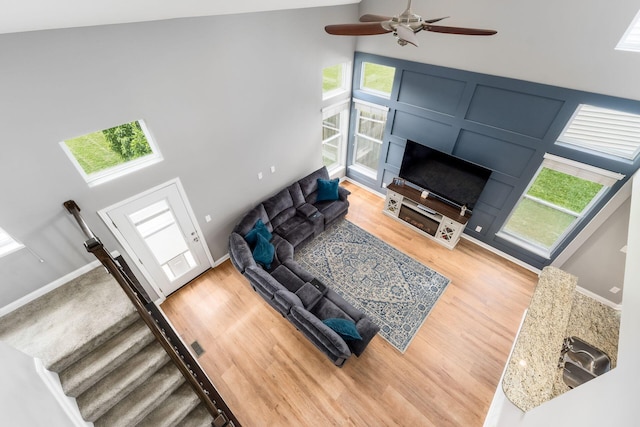 6458 Tallman Ct, Canal Winchester, OH 43110 - living room with light wood-style floors, ceiling fan, a high ceiling, and baseboards