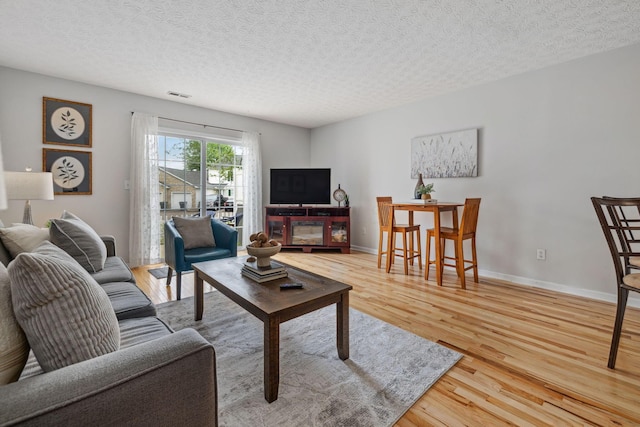 1994 Hoadley Dr Unit 7C, Columbus, OH 43228 - living area featuring light wood finished floors, a textured ceiling, and baseboards