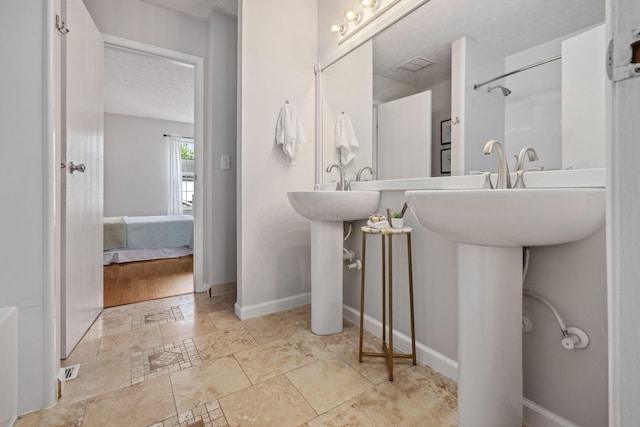 1994 Hoadley Dr Unit 7C, Columbus, OH 43228 - ensuite bathroom featuring a textured ceiling, baseboards, and a sink