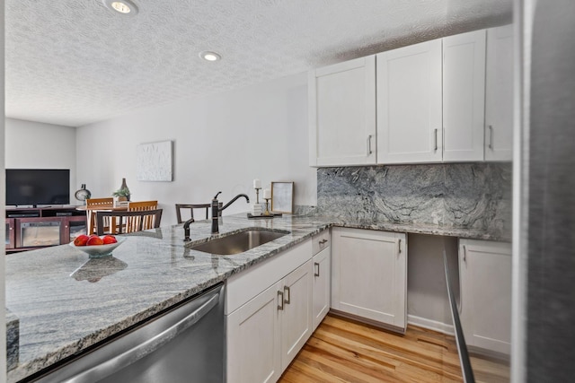 1994 Hoadley Dr Unit 7C, Columbus, OH 43228 - kitchen with dishwasher, a sink, light wood finished floors, white cabinetry, and a textured ceiling