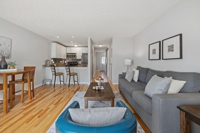 1994 Hoadley Dr Unit 7C, Columbus, OH 43228 - living room featuring light wood-style floors, a textured ceiling, baseboards, and recessed lighting