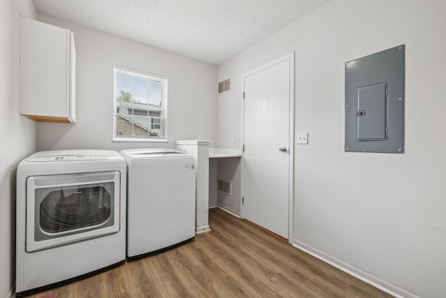 1994 Hoadley Dr Unit 7C, Columbus, OH 43228 - laundry room with electric panel, separate washer and dryer, wood finished floors, cabinet space, and a textured ceiling