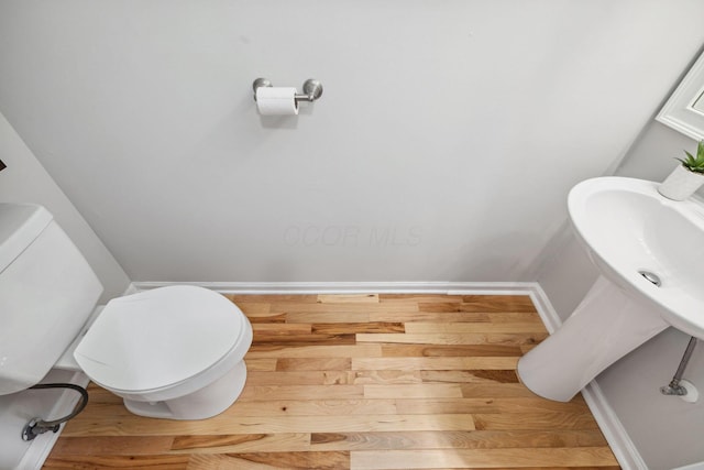 1994 Hoadley Dr Unit 7C, Columbus, OH 43228 - half bathroom with baseboards, wood finished floors, and toilet