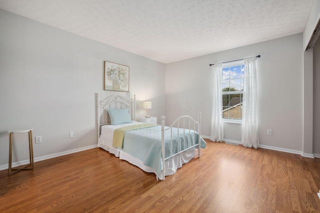 1994 Hoadley Dr Unit 7C, Columbus, OH 43228 - bedroom with wood finished floors, a textured ceiling, and baseboards
