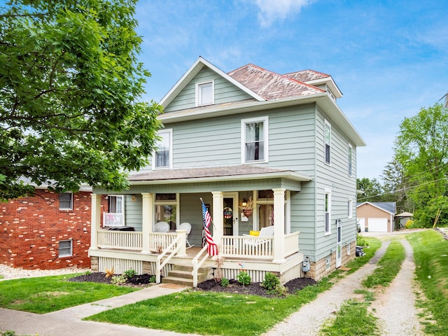 154 Montgomery Blvd, New Concord, OH 43762 - view of front facade with covered porch, driveway, a detached garage, and a front lawn