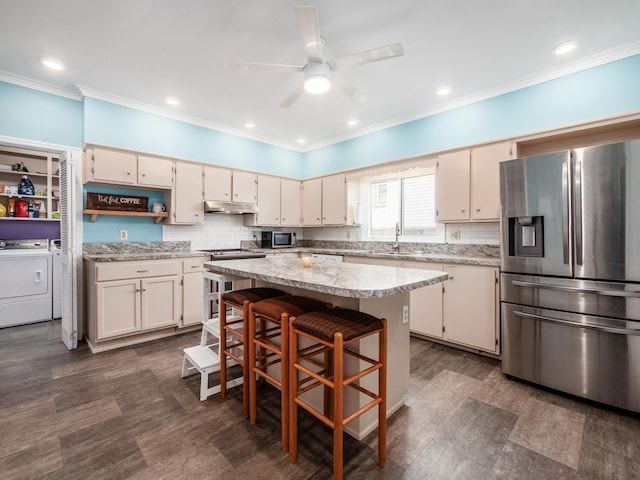 154 Montgomery Blvd, New Concord, OH 43762 - kitchen with appliances with stainless steel finishes, under cabinet range hood, independent washer and dryer, a sink, and crown molding