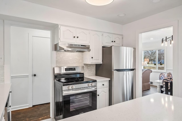225 W Heffner St, Delaware, OH 43015 - kitchen featuring stainless steel appliances, under cabinet range hood, white cabinets, decorative backsplash, and dark wood-type flooring