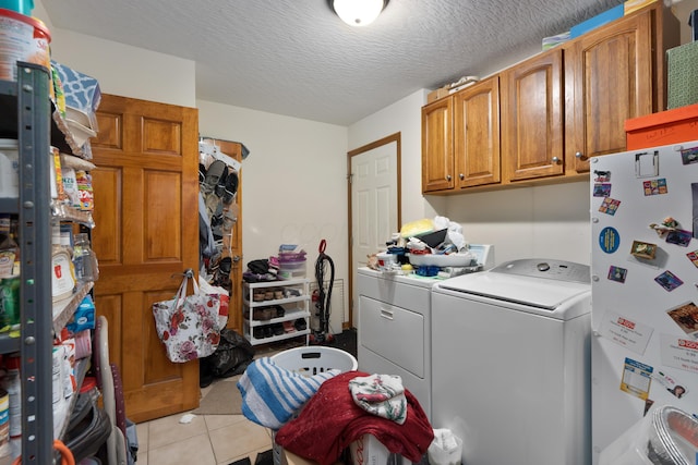 7415 Sand Spurrey Ct, Westerville, OH 43082 - laundry room featuring independent washer and dryer, cabinet space, light tile patterned floors, and a textured ceiling