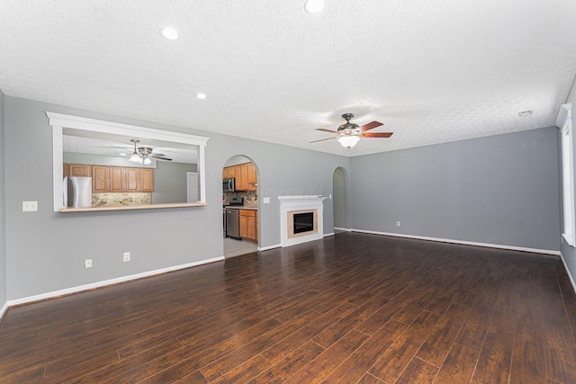 5924 Morrissey St Unit 5924E, Columbus, OH 43232 - unfurnished living room featuring a ceiling fan, a textured ceiling, arched walkways, wood finished floors, and baseboards