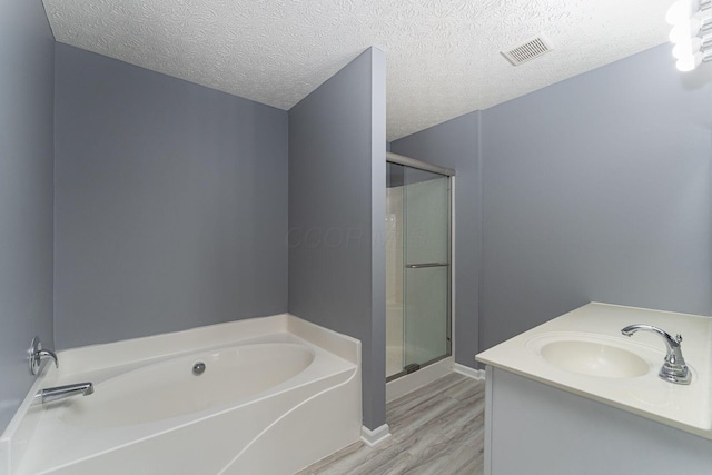 5924 Morrissey St Unit 5924E, Columbus, OH 43232 - full bathroom featuring a garden tub, a stall shower, wood finished floors, vanity, and a textured ceiling