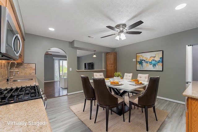 5924 Morrissey St Unit 5924E, Columbus, OH 43232 - dining room featuring arched walkways, ceiling fan, light wood finished floors, baseboards, and recessed lighting